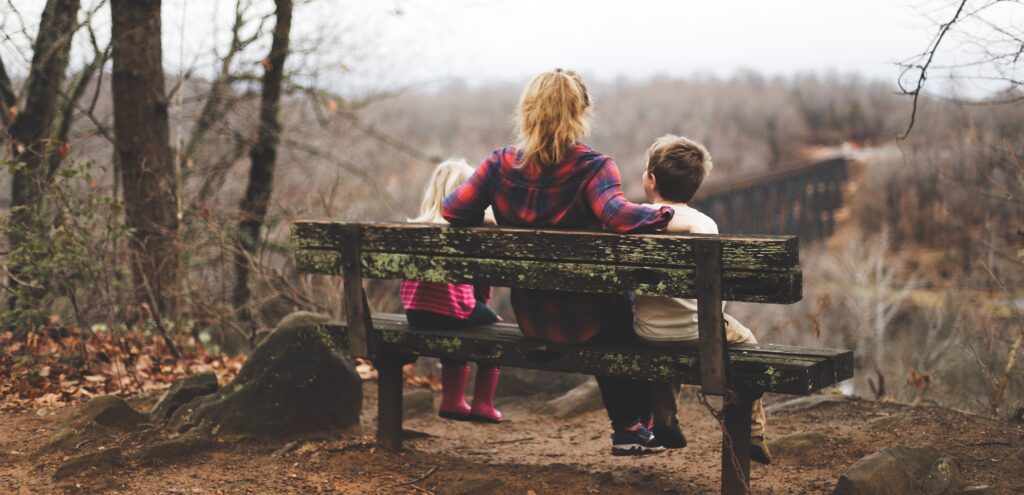 woman and two children sitting on a bench